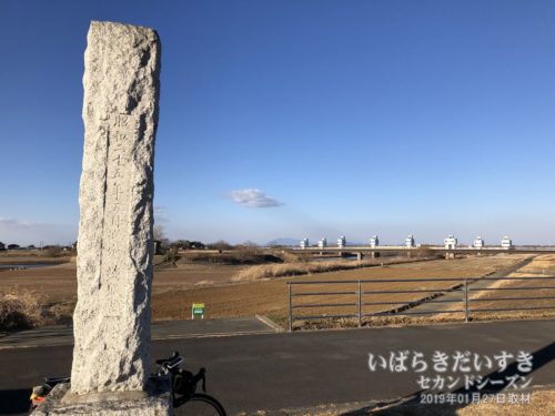 堤防上の茨城百景碑越しに新岡堰を望む。